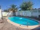Beautiful backyard pool with clear water, inviting seating, and mature trees providing shade at 1828 Hassett Ave, Las Vegas, NV 89104