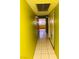 Hallway with tile flooring leading to a kitchen with bright yellow cabinets at 3688 Edison Ave, Las Vegas, NV 89121