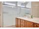 Bathroom featuring a vanity and double sinks, along with a glass enclosed shower at 7457 Widewing Dr, North Las Vegas, NV 89084