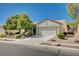 Inviting single-Gathering home with desert landscaping, a concrete driveway, and a white garage door at 7457 Widewing Dr, North Las Vegas, NV 89084