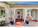 Close-up of the front porch with potted flowers, decorative accents, and a screen door at 7457 Widewing Dr, North Las Vegas, NV 89084