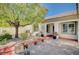 Quaint front courtyard with pavers, potted plants, desert landscaping, and a mature shade tree at 7457 Widewing Dr, North Las Vegas, NV 89084