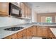 Functional kitchen featuring wood cabinets, granite countertops, and built-in appliances at 7457 Widewing Dr, North Las Vegas, NV 89084