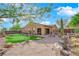 Beautiful backyard featuring a putting green, brick patio, and lush landscaping at 45 Moltrasio Ln, Henderson, NV 89011