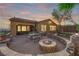 Relaxing backyard featuring a fire pit, patio, built-in grill, and mature desert landscaping at 45 Moltrasio Ln, Henderson, NV 89011