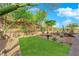 Private backyard with synthetic grass, a fountain, and views of surrounding landscape at 45 Moltrasio Ln, Henderson, NV 89011