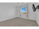 Bright, carpeted bedroom with mounted flatscreen TV and window with pleated shades at 45 Moltrasio Ln, Henderson, NV 89011