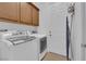 Modern laundry room with front-load washer and dryer and overhead storage at 45 Moltrasio Ln, Henderson, NV 89011