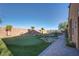 Lush putting green surrounded by mature trees and rock accents in the landscaped backyard at 45 Moltrasio Ln, Henderson, NV 89011