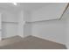 Bright walk-in closet boasts ample storage with wooden clothing rods and neutral carpeting at 45 Moltrasio Ln, Henderson, NV 89011
