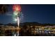 Night view of a waterfront community with vibrant fireworks lighting up the sky at 45 Moltrasio Ln, Henderson, NV 89011