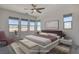 Virtually staged main bedroom with large windows and a comfortable sitting area at 9807 Ravenstone St, Las Vegas, NV 89141