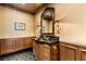 Elegant powder room featuring stylish dark wood vanity with black countertop and gold fixtures at 1309 Imperia Dr, Henderson, NV 89052