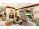 Elegant living room with a fireplace, comfortable seating, and large windows overlooking the lush grounds at 1309 Imperia Dr, Henderson, NV 89052