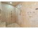 Modern walk-in shower with luxurious hardware and stone tile in an elegant and bright bathroom at 1309 Imperia Dr, Henderson, NV 89052