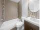 Modern bathroom with tiled shower-tub combo, stylish vanity, and wood-look floor at 1195 Sunfire St, Henderson, NV 89014