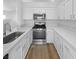 Modern kitchen with white cabinets, quartz countertops, and stainless steel appliances at 1195 Sunfire St, Henderson, NV 89014