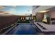 Modern pool area with outdoor kitchen, desert landscaping, and elegant stone patio at 25 Canyon Bay Dr, Henderson, NV 89011
