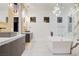 Upscale bathroom featuring a large soaking tub, glass-enclosed shower, marble accent wall, and double vanity sinks at 8780 Haven St, Las Vegas, NV 89123