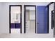 Hallway showcasing an ensuite bathroom and walk-in closet, each featuring unique gray and blue door accents at 8780 Haven St, Las Vegas, NV 89123