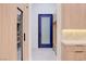 Hallway with light wood cabinets with drink fridge and shelves and blue door at 8780 Haven St, Las Vegas, NV 89123