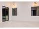 Modern living room with white walls, tile flooring, black window trim, and sliding glass doors to the outdoor patio at 8780 Haven St, Las Vegas, NV 89123