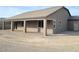 Rear view of house showcasing covered patio and landscaping at 4761 E Sandalwood Dr, Pahrump, NV 89061