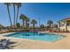 Beautiful community pool area with palm trees, seating, and a nearby building for residents to enjoy at 5701 Pearldrop Ave, Las Vegas, NV 89107