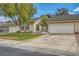 Inviting single-story house featuring a well-kept lawn, mature tree, and attached two-car garage at 5701 Pearldrop Ave, Las Vegas, NV 89107