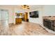 Open living room showcases laminate flooring, a brick fireplace, and an open view to the kitchen at 5701 Pearldrop Ave, Las Vegas, NV 89107