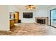 Spacious living area featuring wood floors, brick fireplace, and TV at 5701 Pearldrop Ave, Las Vegas, NV 89107