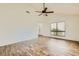 Open living room with vaulted ceilings, modern flooring, a ceiling fan, and a large window at 5701 Pearldrop Ave, Las Vegas, NV 89107