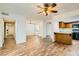 Bright living room with wood floors, ceiling fan, and open layout to dining and kitchen at 5701 Pearldrop Ave, Las Vegas, NV 89107