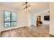 Bright living room with wood flooring, modern light fixture, and large windows at 5701 Pearldrop Ave, Las Vegas, NV 89107