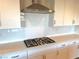 Gas cooktop with stainless steel range hood and white cabinets at 9902 Belikove Manor Ave, Las Vegas, NV 89178