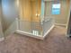 Upstairs hall with light carpet and railing at 9902 Belikove Manor Ave, Las Vegas, NV 89178