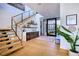 Bright and modern foyer featuring hardwood floors, a glass-railed staircase, and a stylish bar area, creating an inviting space at 4915 Summit Overlook Dr, Las Vegas, NV 89135
