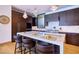 Bright kitchen with dark wood cabinets, marble countertops, island and pendant lighting at 4915 Summit Overlook Dr, Las Vegas, NV 89135