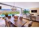 Open-concept living and dining area with mountain views, modern fireplace, chandelier, and access to a pool at 4915 Summit Overlook Dr, Las Vegas, NV 89135
