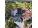 Bird's-eye view of this home featuring a unique facade, clay tile roof, and verdant landscaping with golf course views at 73 Princeville Ln, Las Vegas, NV 89113