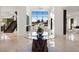 Bright foyer with a glass table, stone base, and view of the backyard, complemented by a staircase at 73 Princeville Ln, Las Vegas, NV 89113