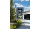 Beautiful modern home featuring a stone accent wall entrance, manicured landscaping and a paved driveway at 73 Princeville Ln, Las Vegas, NV 89113