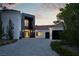 Stylish home boasting a stone accent wall entrance, black garage doors, fresh landscaping, and a paved driveway at 73 Princeville Ln, Las Vegas, NV 89113