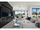 Well-lit living room with views of the golf course, modern furnishings, and a wall-mounted entertainment center at 73 Princeville Ln, Las Vegas, NV 89113