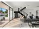 Open-concept living area with sliding glass doors, sleek staircase, and comfortable seating arrangement at 73 Princeville Ln, Las Vegas, NV 89113