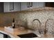 Close-up of wet bar featuring elegant backsplash and modern faucet at 73 Princeville Ln, Las Vegas, NV 89113