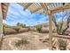 Fenced backyard with desert landscaping and a covered patio at 10909 Bramante Dr, Las Vegas, NV 89141