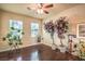 Bright bedroom featuring hardwood floors, neutral walls, a ceiling fan, and natural light from two windows at 10909 Bramante Dr, Las Vegas, NV 89141