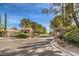 Gated community entrance with stone pillars, wrought iron gates, and mature landscaping, providing privacy at 10909 Bramante Dr, Las Vegas, NV 89141