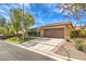 Attractive single-story home featuring a spacious driveway and well-maintained front yard with mature trees at 10909 Bramante Dr, Las Vegas, NV 89141